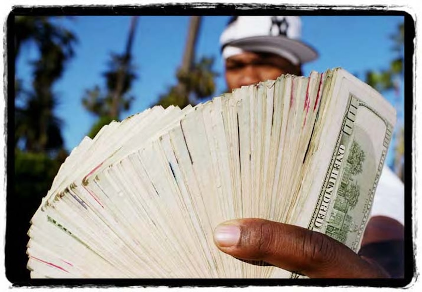 Photograph of 50 CENT holding a money fan
