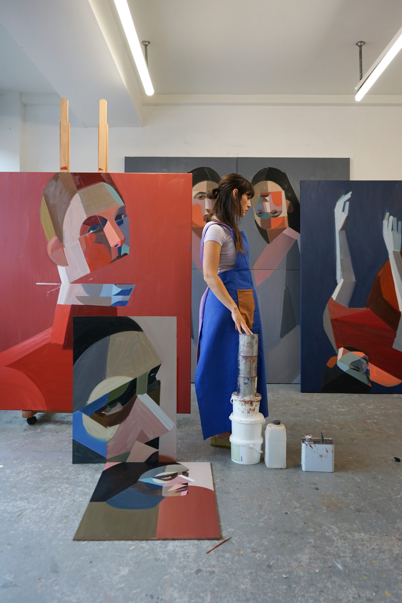 Image of painter Kat Kristof in her studio, surrounded by her paintings